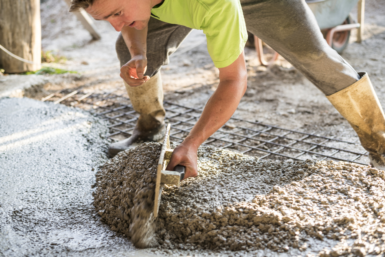 Man leveling wet concrete using a trowel