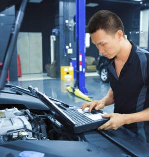 Mechanic using Diagnostic machine tools for car