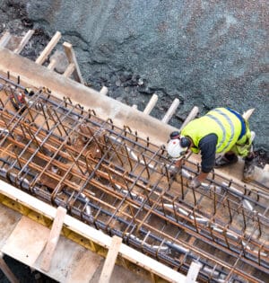 Tromso, Norway - August 3th, 2018:  Top view of a builder worker working on a concrete construction under the bridge of Tromso, Norway