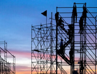 The workers are climbing the silhouette of scaffolding in the high altitude, horizontal and vertical scaffolding formed a myriad of grid, industrial and modern urban construction background