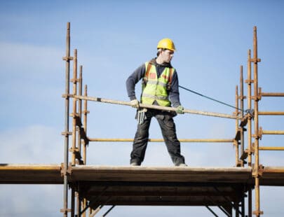 Construction worker setting up scaffolding.