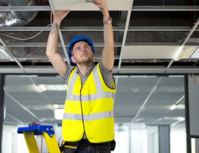 electrician fitting a sensor in office refurb