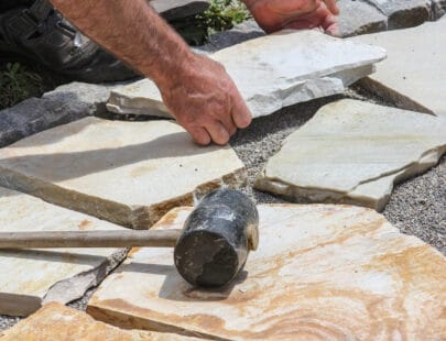Paver with marble plates Worker ist paving a place in the garden.